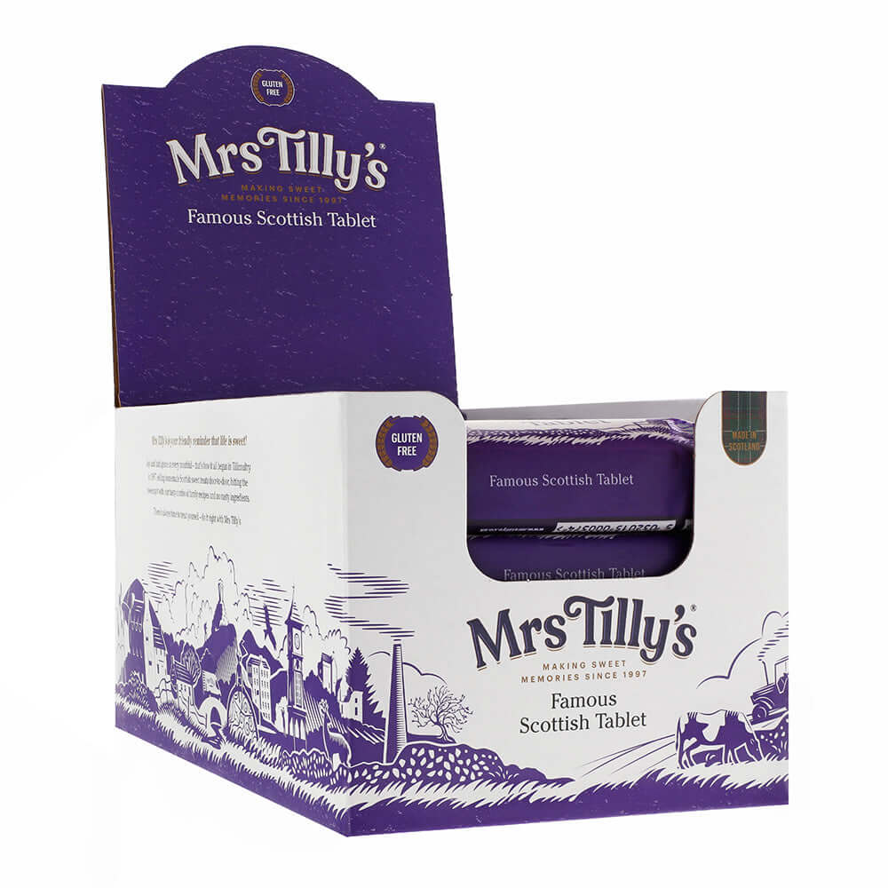 Open retail display box of Mrs Tilly's Famous Scottish Tablet, showcasing individually wrapped bars inside. The packaging features a traditional Scottish village illustration, tartan branding, and gluten-free certification, emphasising its Scottish heritage.